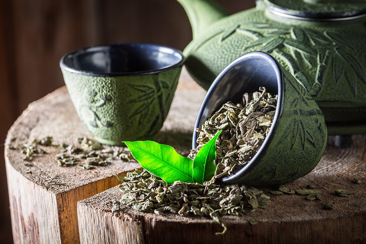 green tea leaves, tea cups and tea pot