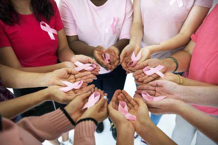 people holding breast cancer ribbons people holding breast cancer ribbons